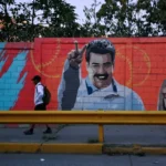 A man walks past a mural showing Venezuela's President Nicolas Maduro and his wife Cilia Flores, after US President Donald Trump said on Saturday the US has struck Venezuela and captured Maduro, in Caracas, Venezuela January 3, 2026 (credit: REUTERS/Maxwell Briceno)